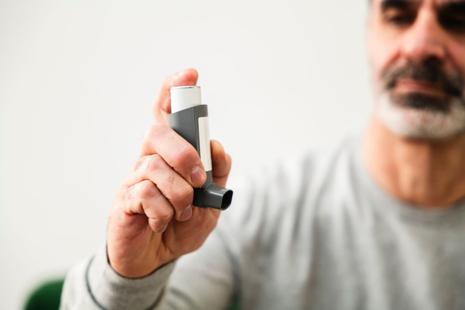 Man with COPD reviewing life insurance paperwork with advisor at kitchen table